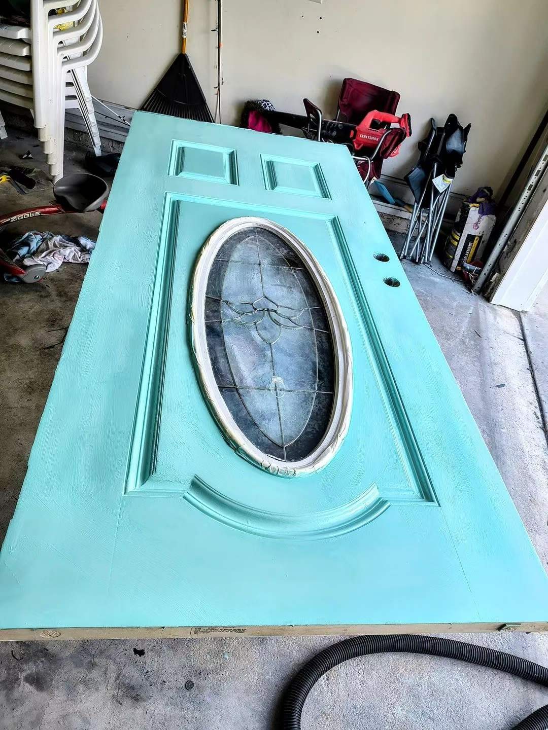 Removed glazed front entry door in a turquoise finish before repainting.