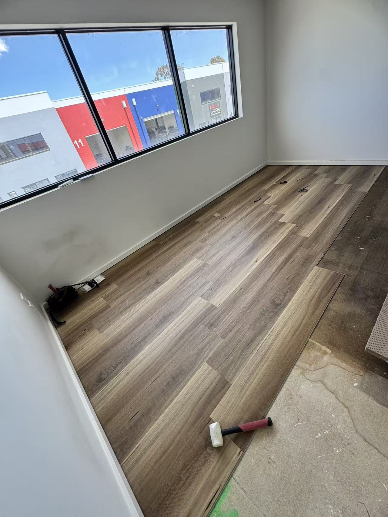 Timber-look floor boards during installation across the room.