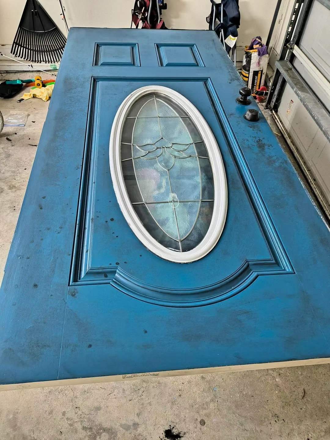Front door during surface preparation and repainting on a work stand.