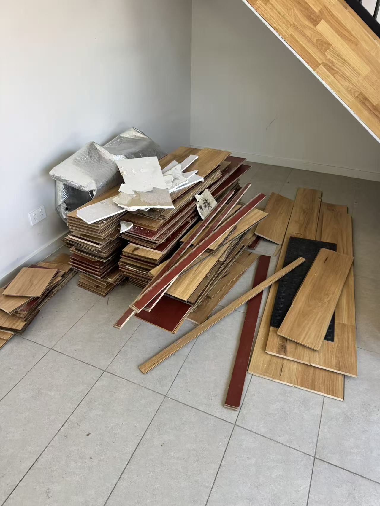 Stack of removed existing flooring inside the room during preparation.